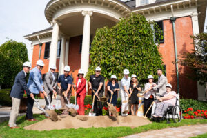 A group of donors for the Ronald McDonald House Access for All project shovel dirt. 