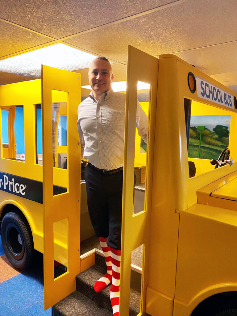 NIck stands in the Fisher PRice Play bus wearing this striped socks.