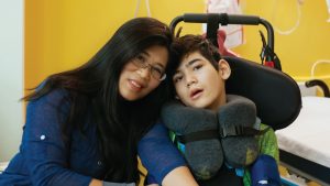 asian mother and special needs son together in hospital room